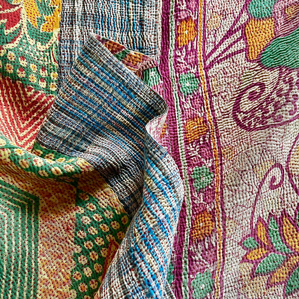 Handcrafted Vintage Kantha Quilt – Fluid Leaf & Paisley Twirls flat lay showing dynamic paisley twirls in vibrant pink, purple, green and orange