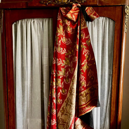 Handcrafted Vintage Kantha Quilt – Free Flow Foliage styled against a wardrobe, showing flowing flowers and foliage in soft taupe, beige and yellow on muted red